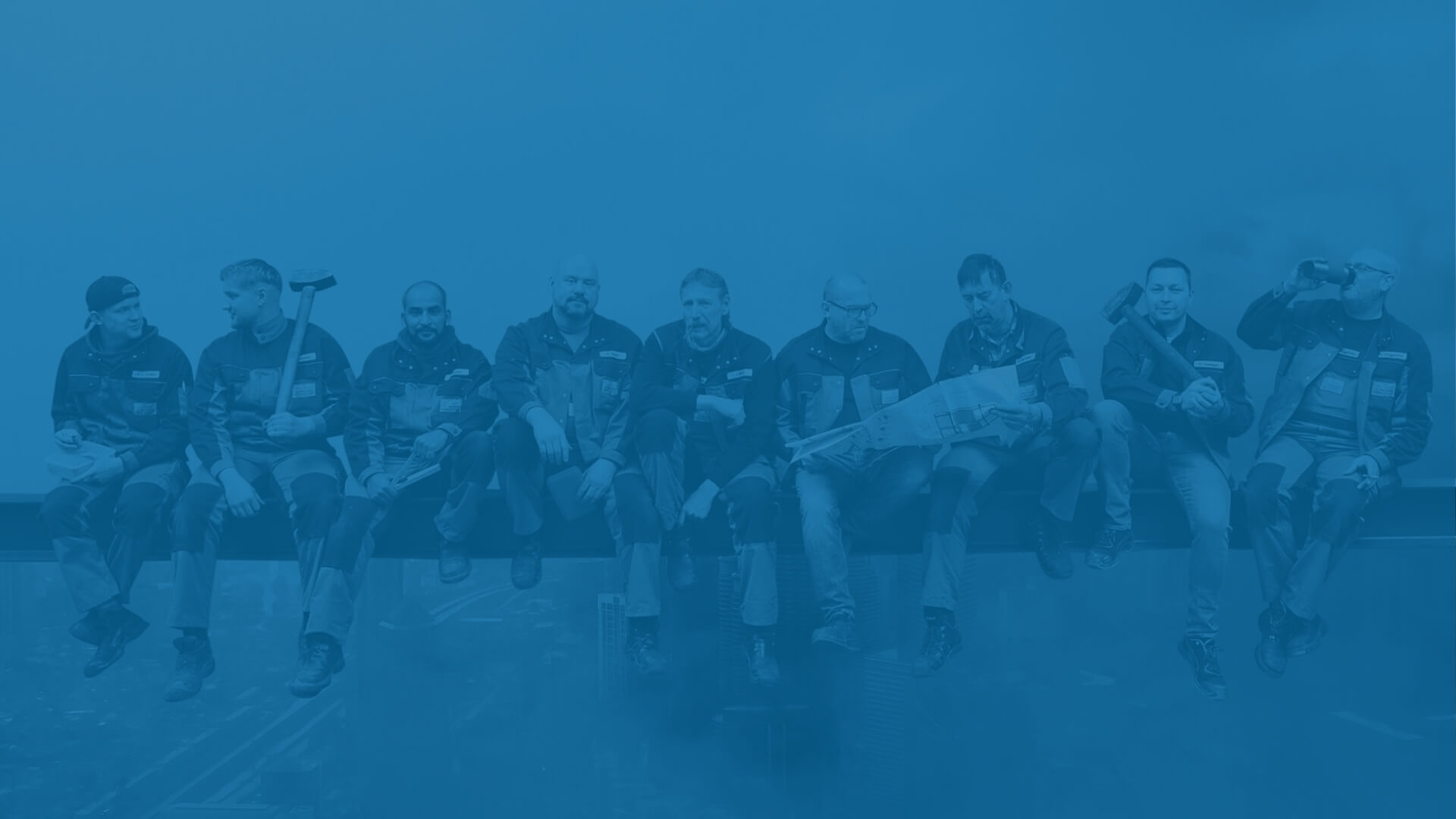 Das Team von Schröder Zaun- und Metallbau auf einem schwebenden Stahlträger.